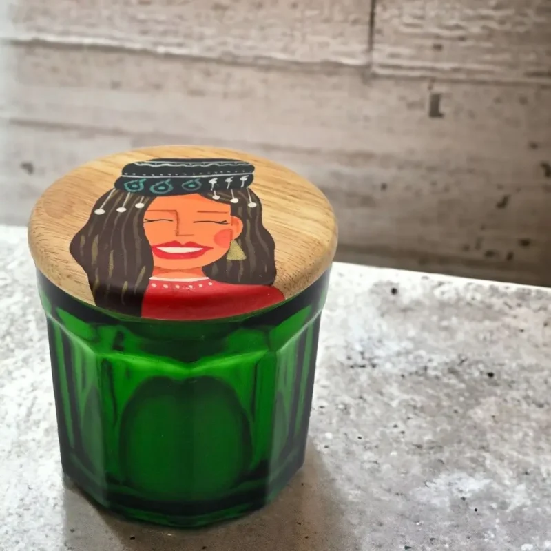 green jar and wooden lid with hand painting