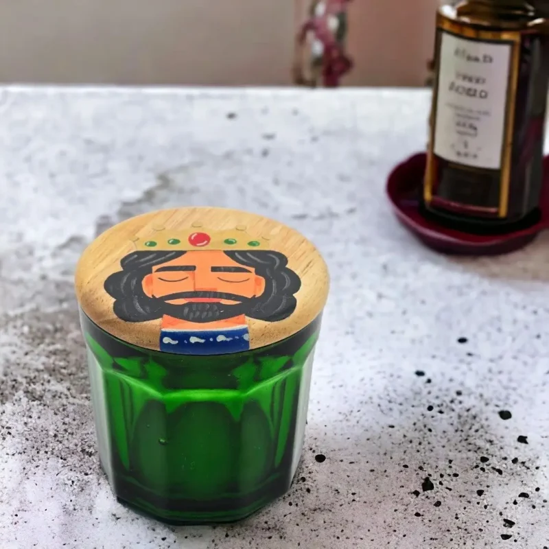 green jar and wooden lid with hand painting